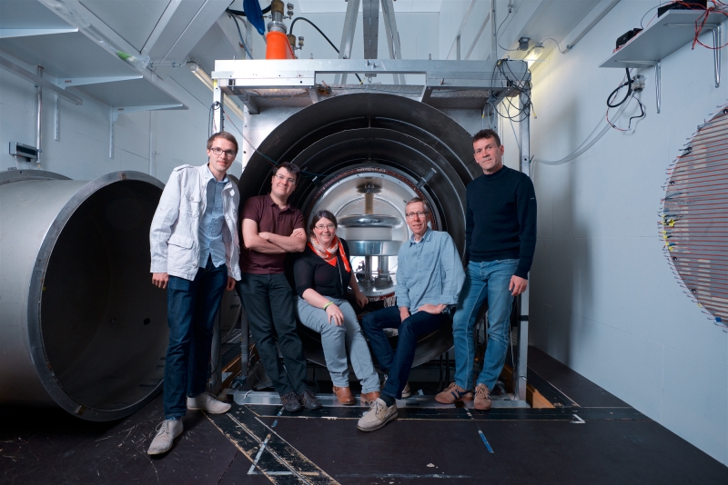 Yoann Kermaidic (anciennement LPSC), Guillaume Pignol (LPSC), Stéphanie Roccia (anciennement IJCLab), Dominique Rebreyend (LPSC), Thomas Lefort (LPCC) chercheurs dans l’expérience nEDM photographiés devant l’expérience nEDM à PSI, Zurich.